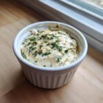 A white ramekin filled with creamy Copycat Pizza Garlic Parmesan Dip Sauce, topped with parsley.
