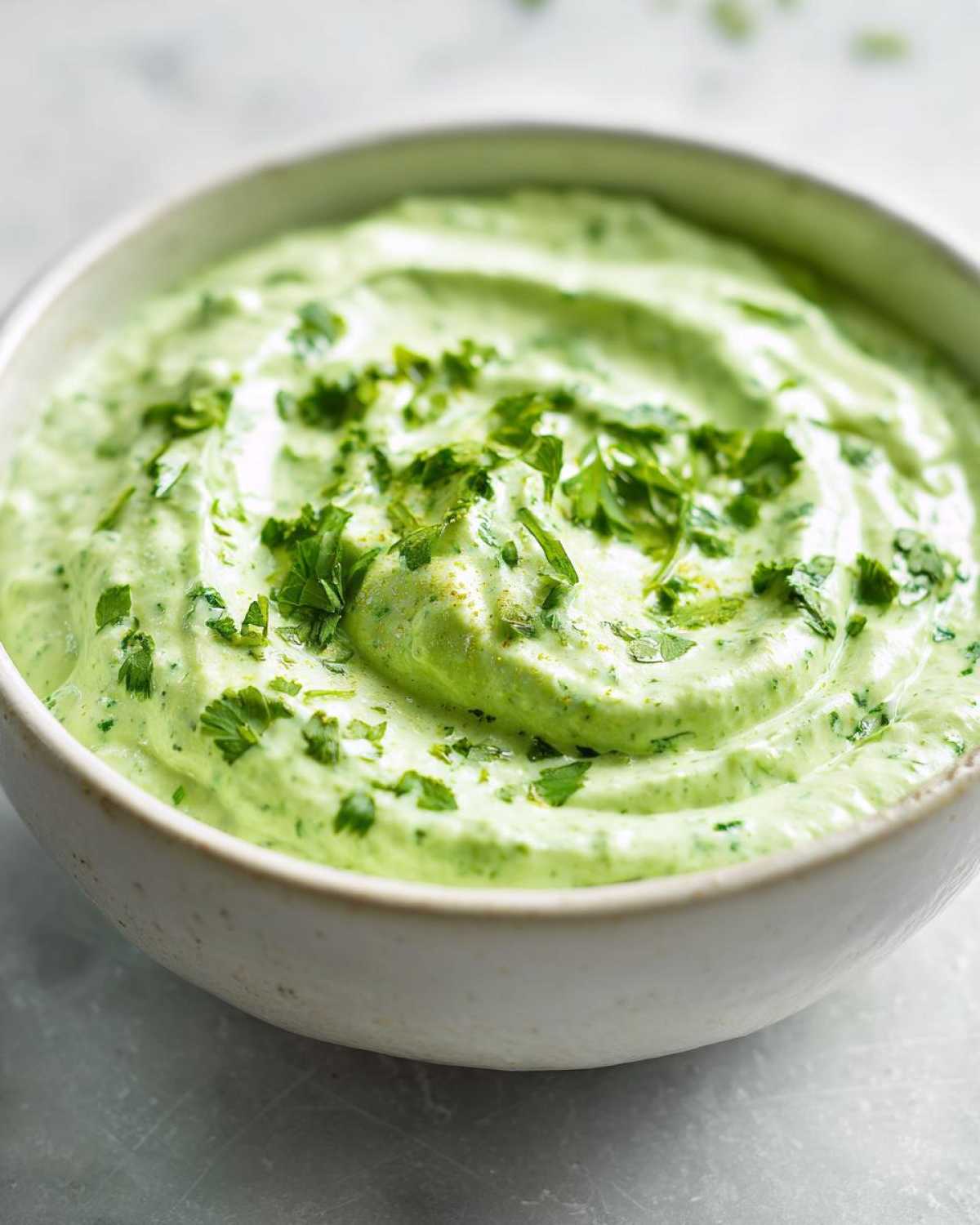 Close-up of a creamy, vibrant green Easy 5-Minute Salsa Verde Yogurt Dip topped with fresh chopped cilantro.