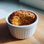 A portion of Gluten-Free Carrot Cake Baked Oats with visible shredded carrots, served in a white ramekin.