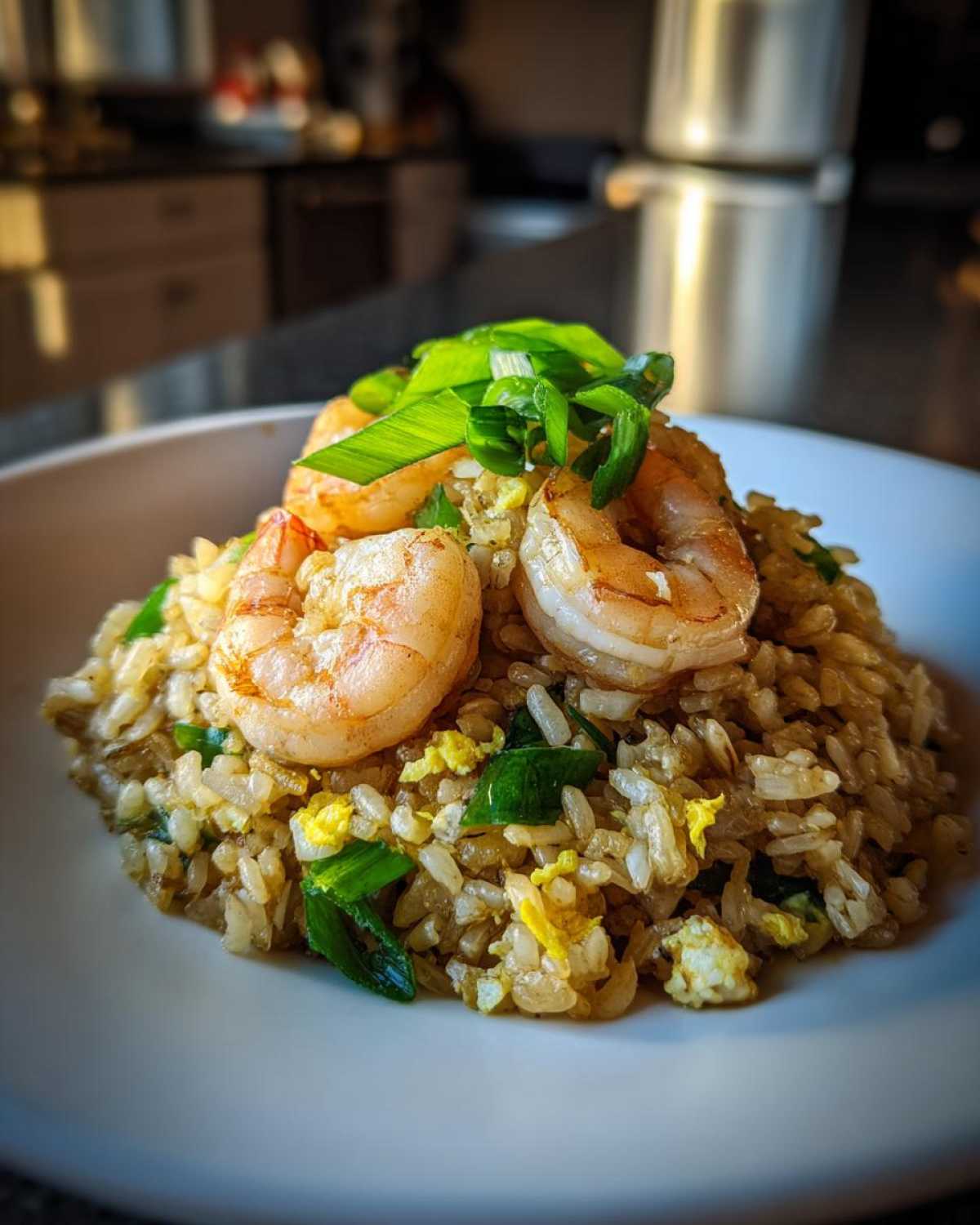 Close-up of Gluten-Free Lemon Pepper Fried Rice topped with sautéed shrimp and green onions.