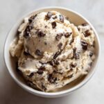 Two scoops of creamy vanilla ice cream loaded with chocolate chips, resembling Greek Yogurt Cookie Dough.