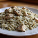 A serving of Instant Pot Creamy Chicken and Orzo, featuring tender chicken pieces mixed with creamy orzo pasta and fresh herbs.