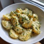 Close-up of Instant Pot Creamy Garlic Butter Potatoes smothered in a rich sauce and topped with fresh parsley.