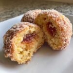Cross-section of two Italian Peach Cookies showing the soft cake texture and jam filling, coated in sugar.