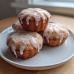 Four golden Mini Lemon Cakes Lavender Glaze stacked slightly on a light gray plate.