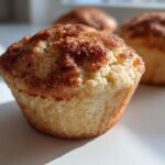 Close-up of a moist Apple Cinnamon Muffin featuring a rich cinnamon sugar crust.