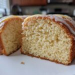 Close-up of a moist slice of London Fog Cake, showing the crumb texture and white vanilla glaze drizzled on top.