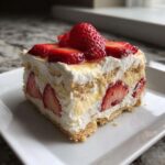 A perfect slice of No-Bake Strawberry Lemon Icebox Cake layered with graham crackers, cream, and fresh strawberries.