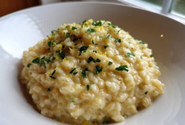 Close-up of creamy One-Pot Creamy Lemon Garlic Farro topped with fresh parsley and lemon zest.