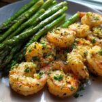 Plated Sheet Pan Crispy Garlic Butter Shrimp and Asparagus, glistening with garlic butter and parsley.