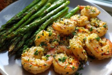 Plated Sheet Pan Crispy Garlic Butter Shrimp and Asparagus, glistening with garlic butter and parsley.
