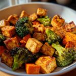 Close-up of crispy Sheet Pan Crispy Honey Mustard Tofu cubes mixed with roasted broccoli florets in a white bowl.