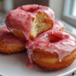 Close-up of fluffy Strawberry Donut Rolls stacked on a white plate, dripping with pink strawberry glaze.