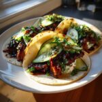 Four Teriyaki Chicken Tacos filled with glazed chicken, creamy sauce, fresh cucumber slices, and sesame seeds.