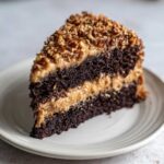 A decadent slice of Texas Tornado Cake showing dark chocolate layers and caramel pecan frosting.