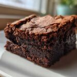 Close-up of a rich, fudgy square of Zero Sugar Brownies with Greek Yogurt on a white plate.