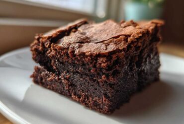 Close-up of a rich, fudgy square of Zero Sugar Brownies with Greek Yogurt on a white plate.