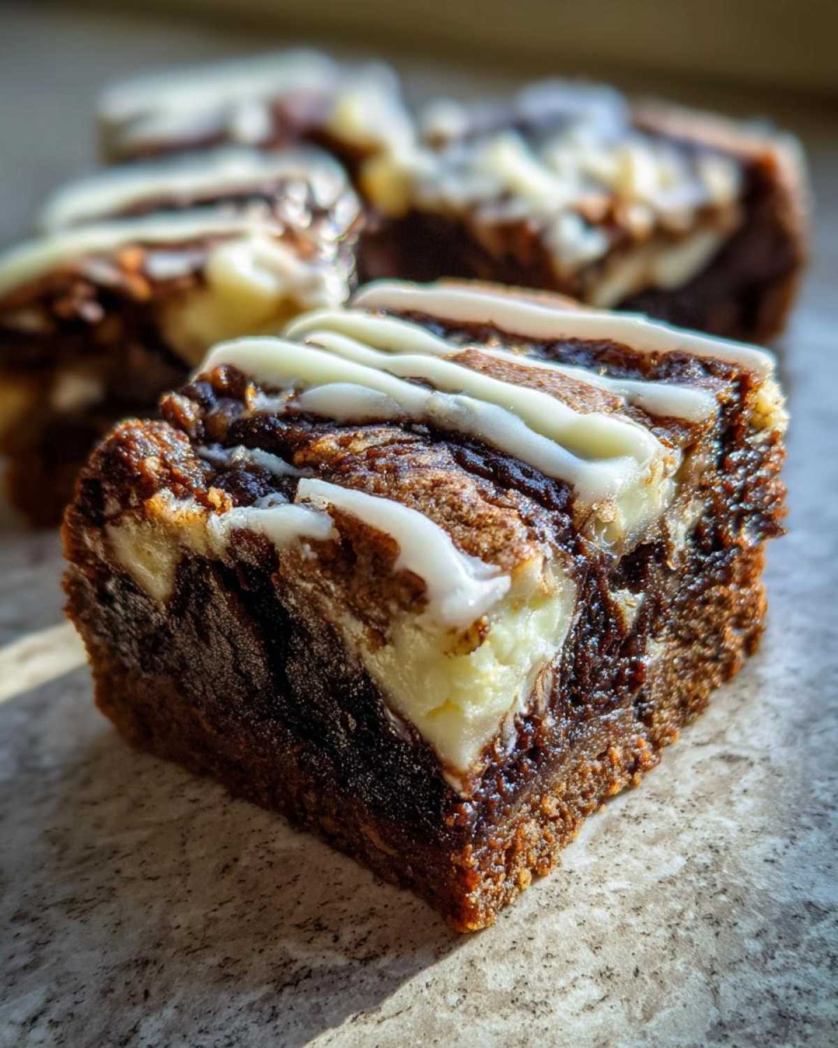 Close-up of a gooey Cinnamon Roll Bliss Bars square with cream cheese swirl and white icing drizzle.