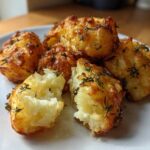 Close-up of perfectly cooked Simple Irish Roasted Potatoes, golden brown and fluffy inside, garnished with fresh thyme.
