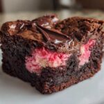 A single, rich square of Strawberry Brownies featuring a dense chocolate base and a bright pink strawberry swirl filling.